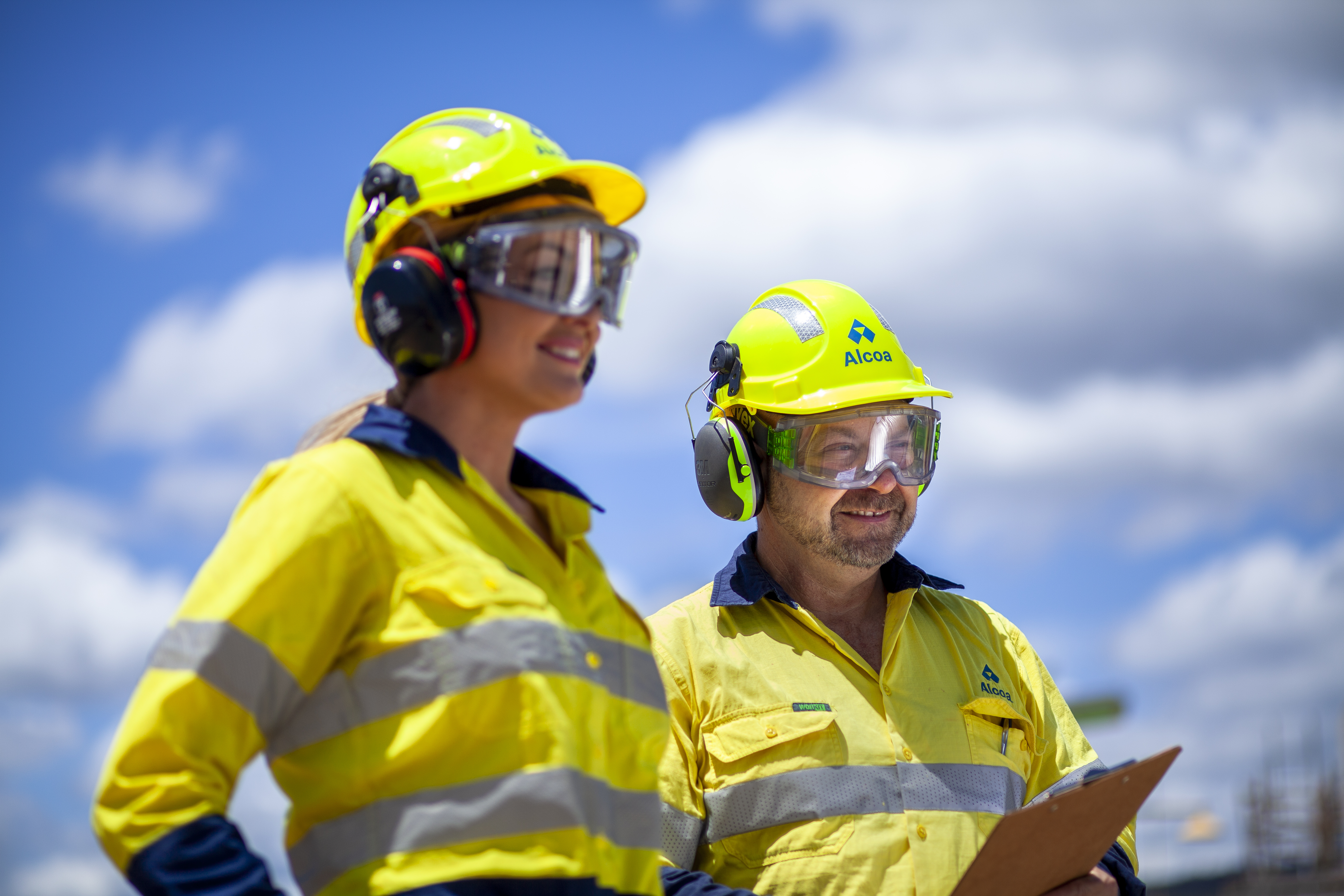 Two individuals in high visibility clothing with a clip board